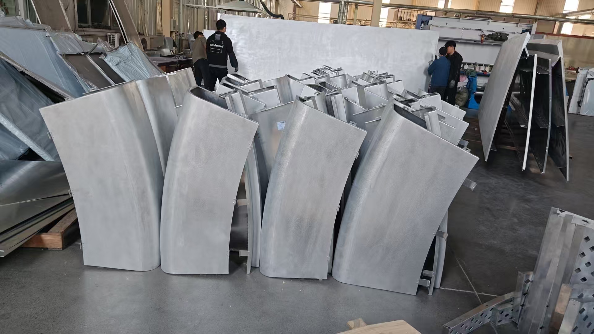 Fabrication photo of grouped curved aluminum solid panel components